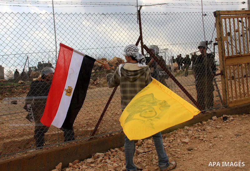 A Palestinian protester holds an Egyptian flag during the weekly demonstration against Israel's separation barrier in the West Bank village of Bilin near Ramallah, Friday, Feb. 11, 2011. Photo by Wagdi Eshtayah