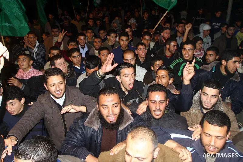 Palestinian Hamas supporters celebrate the news of the resignation of President Hosni Mubarak, who handed control of the country to the military, at night in Deir al-Balah in the central Gaza Strip, Friday, Feb. 11, 2011...