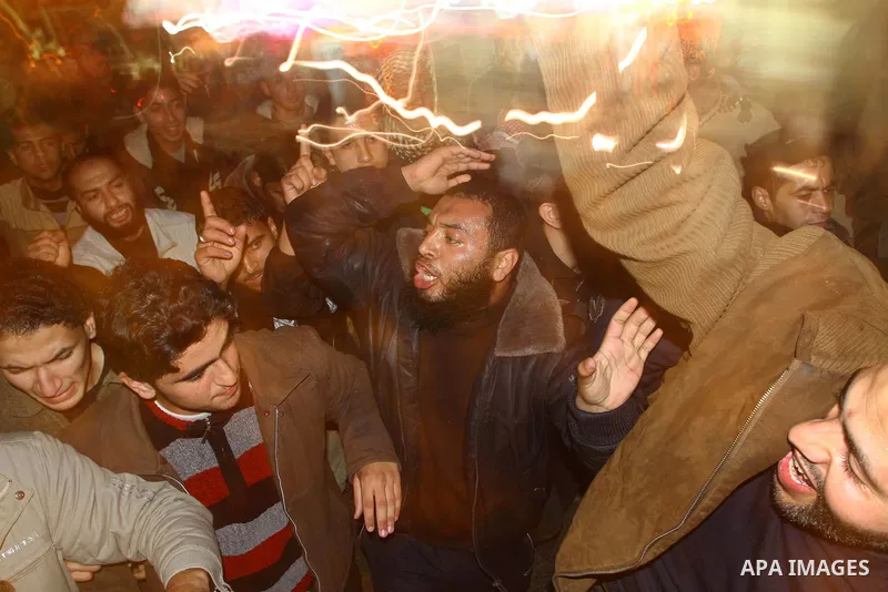 Palestinian Hamas supporters celebrate the news of the resignation of President Hosni Mubarak, who handed control of the country to the military, at night in Deir al-Balah in the central Gaza Strip, Friday, Feb. 11, 2011...