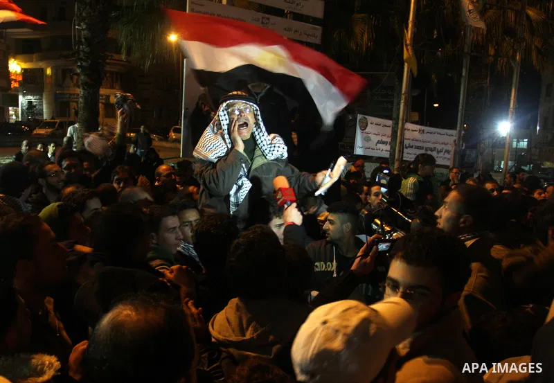 Palestinians celebrate the news of the resignation of President Hosni Mubarak, who handed control of the country to the military, at night in the West Bank city of Ramallah, Friday, Feb. 11, 2011. Photo by Issam Rimawi