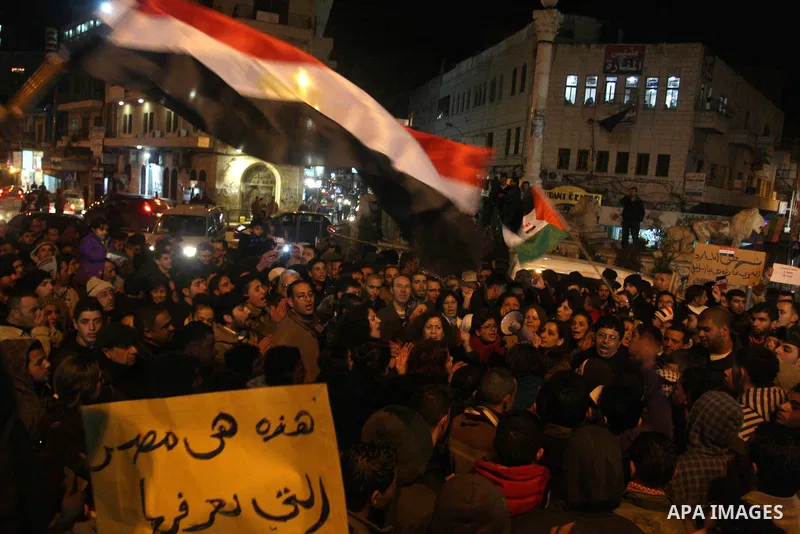Palestinians celebrate the news of the resignation of President Hosni Mubarak, who handed control of the country to the military, at night in the West Bank city of Ramallah, Friday, Feb. 11, 2011. Photo by Issam Rimawi