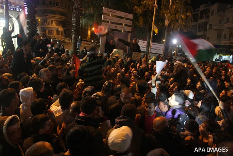 Palestinians celebrate the news of the resignation of President Hosni Mubarak, who handed control of the country to the military, at night in the West Bank city of Ramallah, Friday, Feb. 11, 2011. Photo by Issam Rimawi