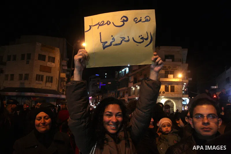Palestinians celebrate the news of the resignation of President Hosni Mubarak, who handed control of the country to the military, at night in the West Bank city of Ramallah, Friday, Feb. 11, 2011. Photo by Issam Rimawi