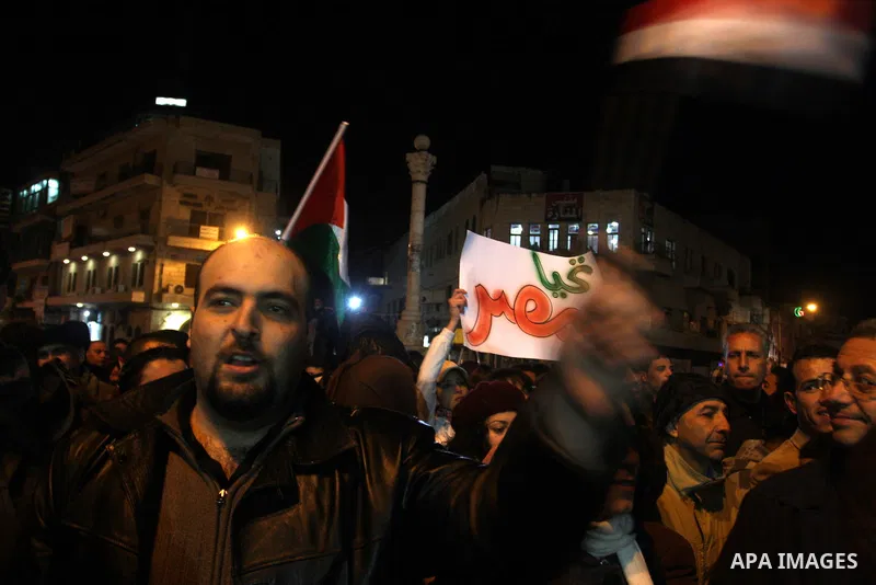 Palestinians celebrate the news of the resignation of President Hosni Mubarak, who handed control of the country to the military, at night in the West Bank city of Ramallah, Friday, Feb. 11, 2011. Photo by Issam Rimawi