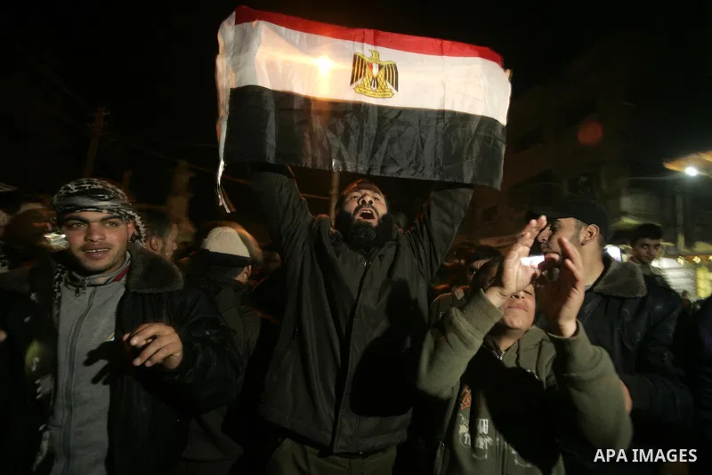 Palestinians celebrate the news of the resignation of President Hosni Mubarak, who handed control of the country to the military, at night in Rafah, southern Gaza Strip, Friday, Feb. 11, 2011. Photo by Abed Rahim Khatib