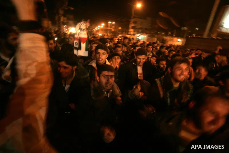 Palestinians celebrate the news of the resignation of President Hosni Mubarak, who handed control of the country to the military, at night in Rafah, southern Gaza Strip, Friday, Feb. 11, 2011. Photo by Abed Rahim Khatib