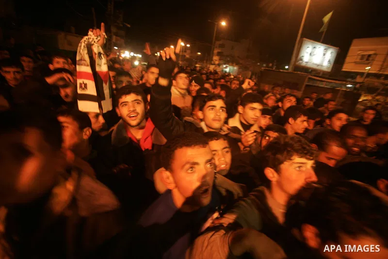Palestinians celebrate the news of the resignation of President Hosni Mubarak, who handed control of the country to the military, at night in Rafah, southern Gaza Strip, Friday, Feb. 11, 2011. Photo by Abed Rahim Khatib