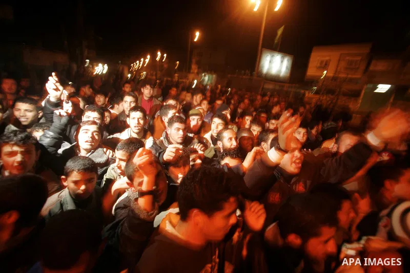 Palestinians celebrate the news of the resignation of President Hosni Mubarak, who handed control of the country to the military, at night in Rafah, southern Gaza Strip, Friday, Feb. 11, 2011. Photo by Abed Rahim Khatib