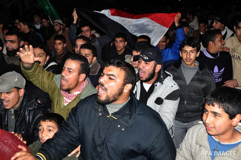 Palestinians celebrate the news of the resignation of President Hosni Mubarak, who handed control of the country to the military, at night in Rafah, southern Gaza Strip, Friday, Feb. 11, 2011. Photo by Abed Rahim Khatib