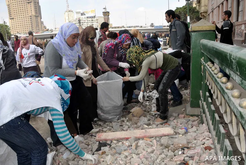 Egyptians clean up garbage and rocks from a street near Tahrir Square in downtown Cairo, Egypt, Saturday, Feb. 12, 2011. Egyptian protesters were jubilant Saturday over their success in ousting former President Hosni Mub...