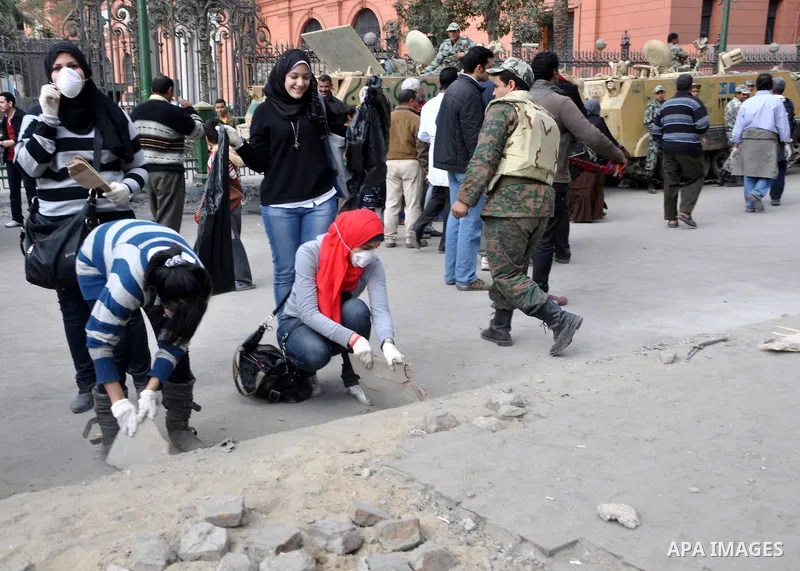 Egyptians clean up garbage and rocks from a street near Tahrir Square in downtown Cairo, Egypt, Saturday, Feb. 12, 2011. Egyptian protesters were jubilant Saturday over their success in ousting former President Hosni Mub...