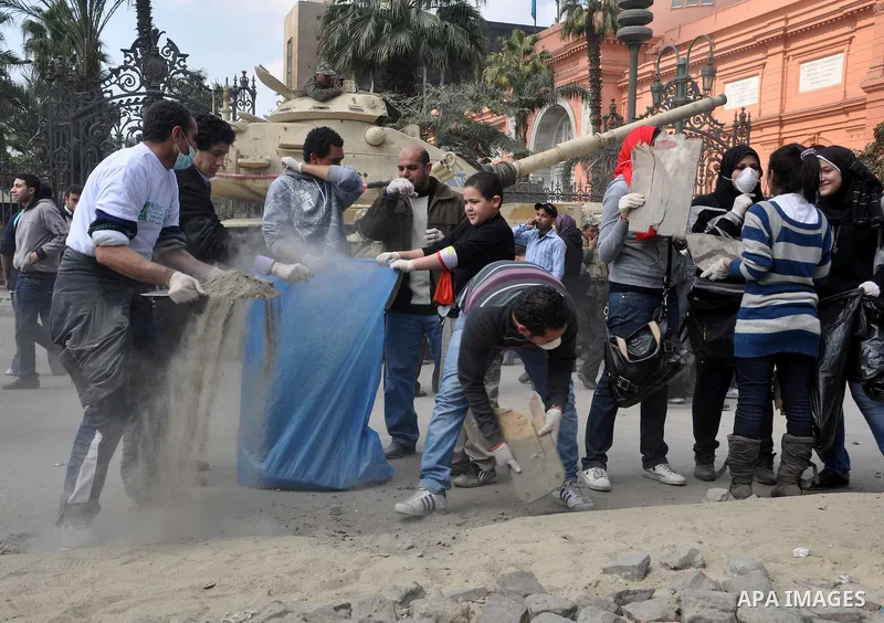 Egyptians clean up garbage and rocks from a street near Tahrir Square in downtown Cairo, Egypt, Saturday, Feb. 12, 2011. Egyptian protesters were jubilant Saturday over their success in ousting former President Hosni Mub...