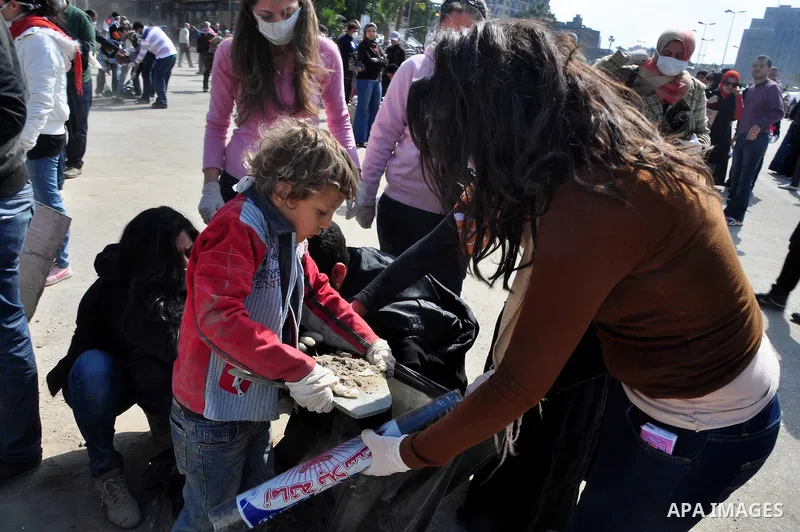 Egyptians clean up garbage and rocks from a street near Tahrir Square in downtown Cairo, Egypt, Saturday, Feb. 12, 2011. Egyptian protesters were jubilant Saturday over their success in ousting former President Hosni Mub...