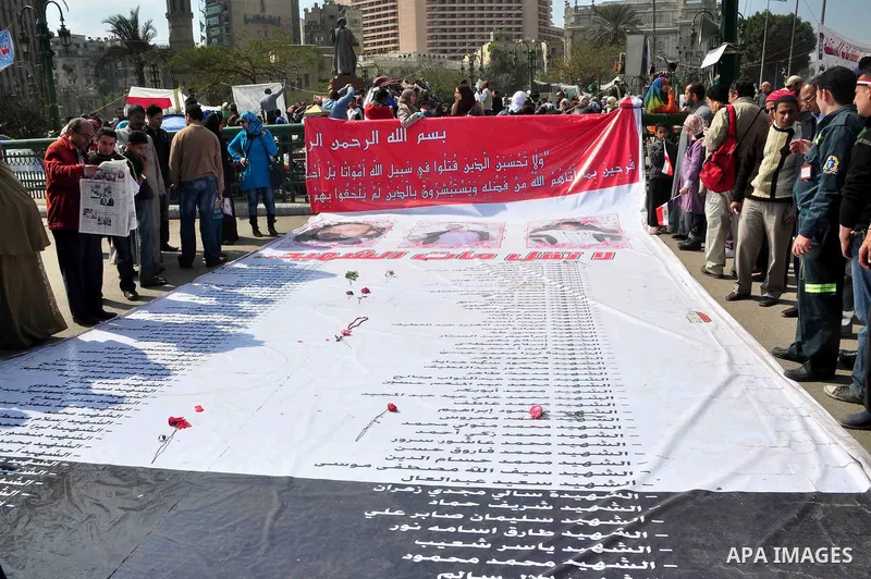 Egyptians stand around a list of martyrs names in Tahrir Square in Cairo, Egypt, Saturday, Feb. 12, 2011. Egypt exploded with joy, tears, and relief after pro-democracy protesters brought down President Hosni Mubarak wit...