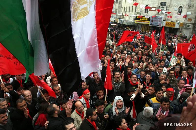 Palestinians wave an Egyptian flag and red flags during a demonstration marking the 29th anniversary of the Palestinian People's Party, a socialist political party, in the West Bank city of Ramallah, Saturday, Feb. 12, 2...