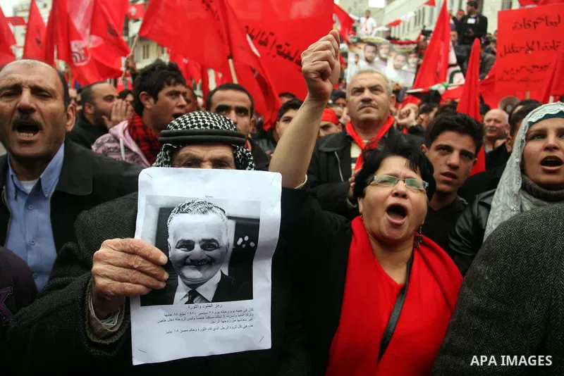 Palestinians wave red flags during a demonstration marking the 29th anniversary of the Palestinian People's Party, a socialist political party, in the West Bank city of Ramallah, Saturday, Feb. 12, 2011. Photo by Issam R...