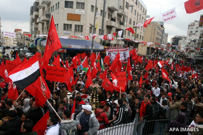 Palestinians wave an Egyptian flag and red flags during a demonstration marking the 29th anniversary of the Palestinian People's Party, a socialist political party, in the West Bank city of Ramallah, Saturday, Feb. 12, 2...