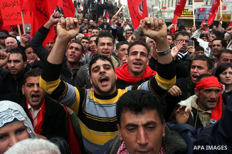 Palestinians wave red flags during a demonstration marking the 29th anniversary of the Palestinian People's Party, a socialist political party, in the West Bank city of Ramallah, Saturday, Feb. 12, 2011. Photo by Issam R...