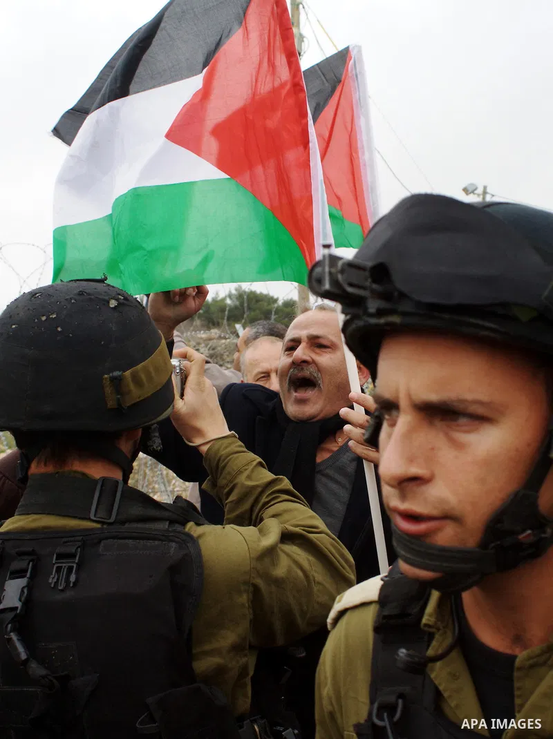 A Palestinian demonstrator argues with an Israeli soldier during a protest against Israel's controversial separation barrier organized by Palestinian and foreign peace activists in the West Bank village of Beit Omar, nea...