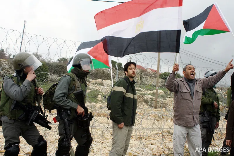 Palestinian demonstrators argue with an Israeli soldiers during a protest against Israel's controversial separation barrier organized by Palestinian and foreign peace activists in the West Bank village of Beit Omar, near...