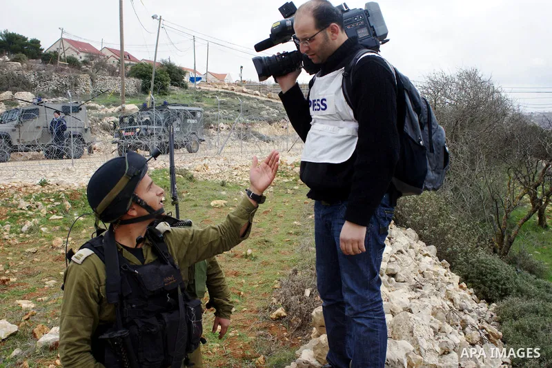 An Israeli soldier scuffles with a cameraman during a protest against Israel's controversial separation barrier organized by Palestinian and foreign peace activists in the West Bank village of Beit Omar, near Hebron, on...