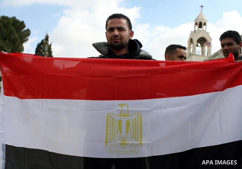 Palestinians hold Egypt and Palestine flags during a protest outside the Church of the Nativity in the West Bank town of Bethlehem 13 February 2011, to show support for the people of Egypt. Photo by Najeh Hashlamoun