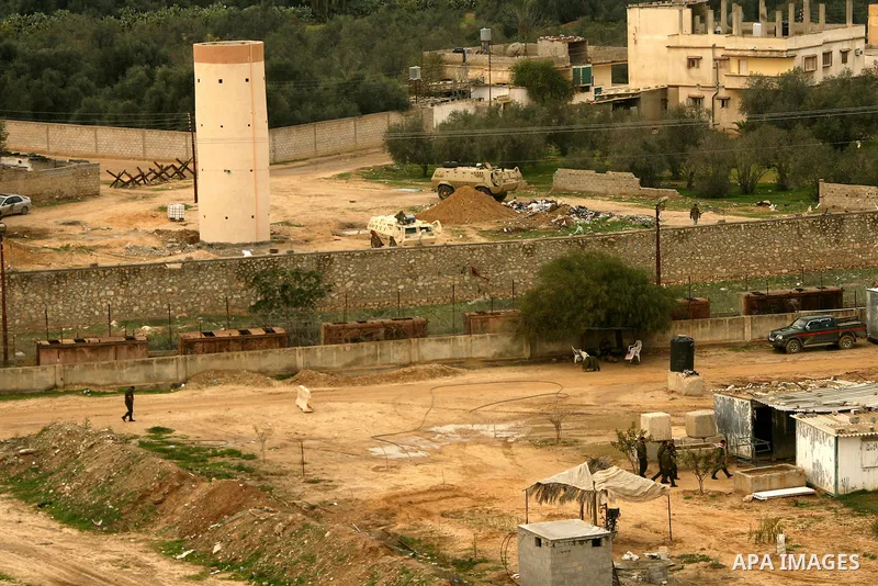 Egyptian soldiers patrol with their army vehicles (rear) their side of the border as Hamas policemen (front) walk along their side of the frontier in this picture taken from the southern Gaza Strip town of Rafah on Febru...