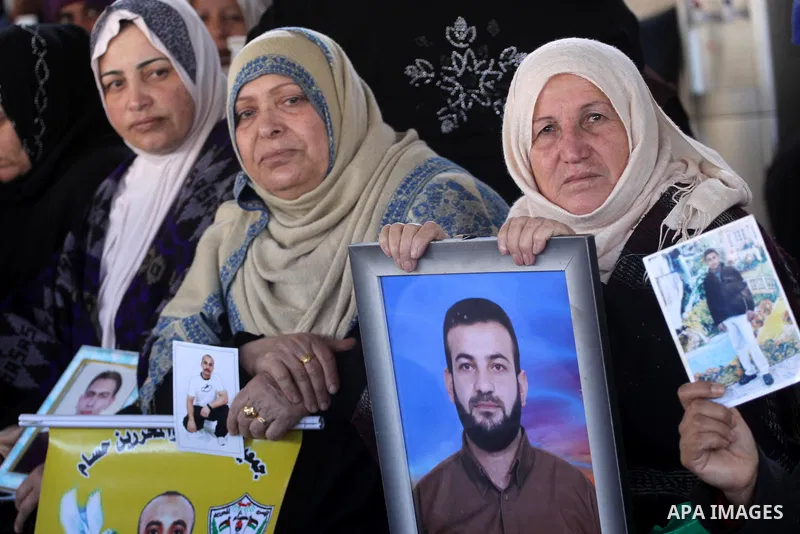 Palestinian women hold pictures of jailed relatives during a protest calling for the release of Palestinian prisoners from Israeli jails at the Red Cross office in Gaza City on Feb. 14,2011. Photo by Mohammed Asad