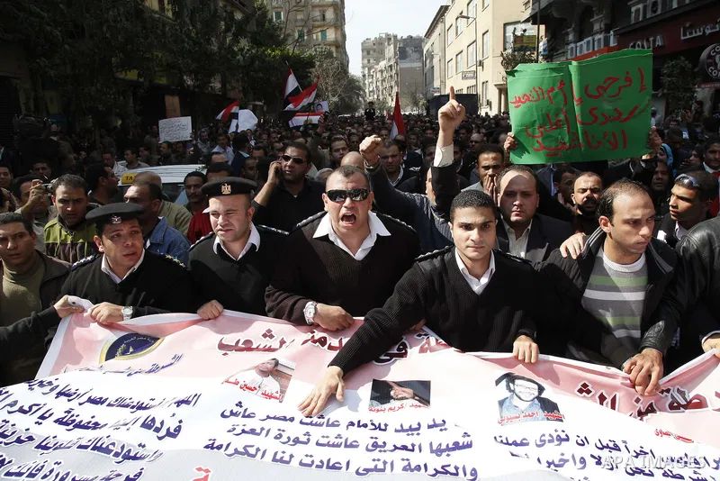 Egyptian police officers and protesters shout ''The police and the people are one hand', in Tahrir Square in downtown Cairo, Egypt Feb. 14, 2011. Egypt's military is taking down the makeshift tents of protesters who camp...