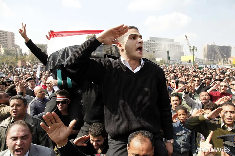 Egyptian police officers and protesters shout ''The police and the people are one hand', in Tahrir Square in downtown Cairo, Egypt Feb. 14, 2011. Egypt's military is taking down the makeshift tents of protesters who camp...