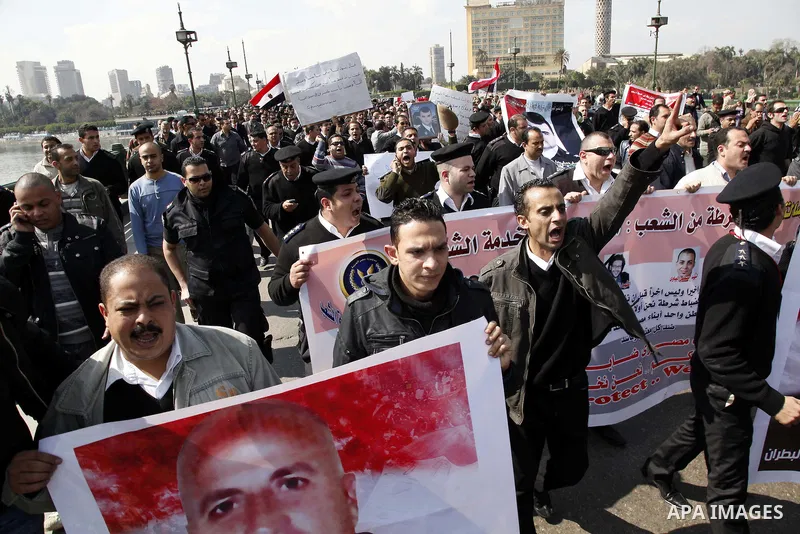Egyptian police officers and protesters shout ''The police and the people are one hand', in Tahrir Square in downtown Cairo, Egypt Feb. 14, 2011. Egypt's military is taking down the makeshift tents of protesters who camp...