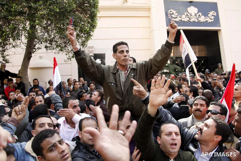 Egyptian police officers and protesters shouts 'The police and the people are one hand', In front of the Ministry of Interior in downtown Cairo, Egypt , Feb. 14, 2011. Egypt's military is taking down the makeshift tents...