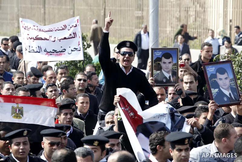 Egyptian police officers and protesters shout ''The police and the people are one hand', in Tahrir Square in downtown Cairo, Egypt Feb. 14, 2011. Egypt's military is taking down the makeshift tents of protesters who camp...