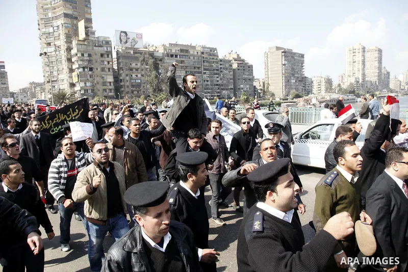 Egyptian police officers and protesters shout ''The police and the people are one hand', in Tahrir Square in downtown Cairo, Egypt Feb. 14, 2011. Egypt's military is taking down the makeshift tents of protesters who camp...