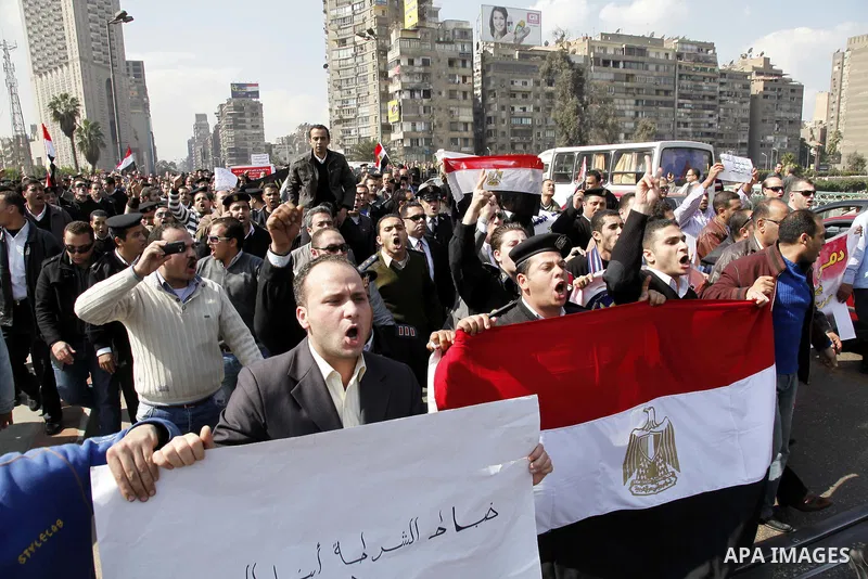 Egyptian police officers and protesters shout ''The police and the people are one hand', in Tahrir Square in downtown Cairo, Egypt Feb. 14, 2011. Egypt's military is taking down the makeshift tents of protesters who camp...