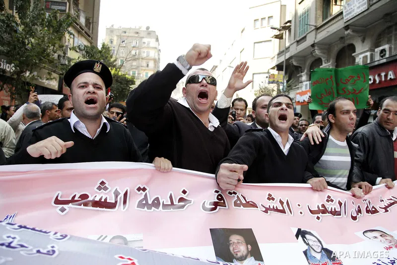 Egyptian police officers and protesters shout ''The police and the people are one hand', in Tahrir Square in downtown Cairo, Egypt Feb. 14, 2011. Egypt's military is taking down the makeshift tents of protesters who camp...