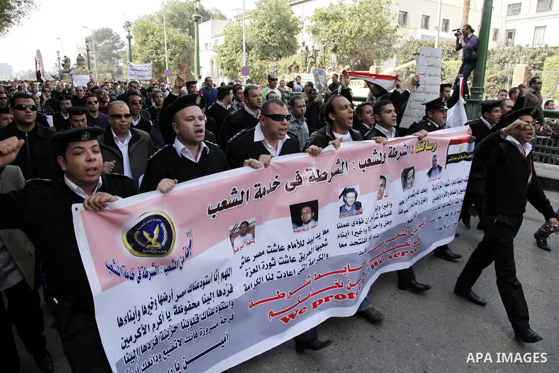 Egyptian police officers and protesters shout ''The police and the people are one hand', in Tahrir Square in downtown Cairo, Egypt Feb. 14, 2011. Egypt's military is taking down the makeshift tents of protesters who camp...