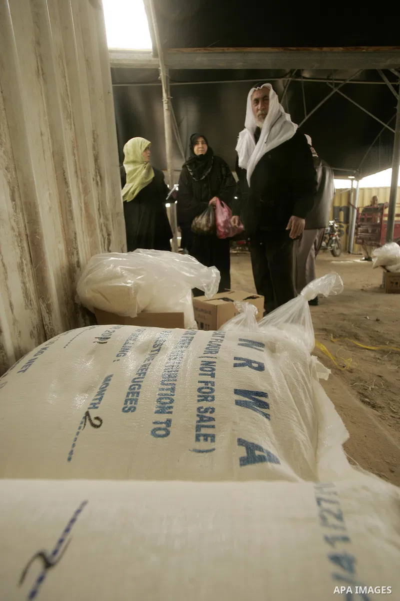 Palestinians receive food aids from the United Nations Relief and Works Agency (UNRWA) at the Rafah refugee camp, in the southern Gaza Strip on February 16, 2011. Accused the owners of destroyed houses that the Relief an...