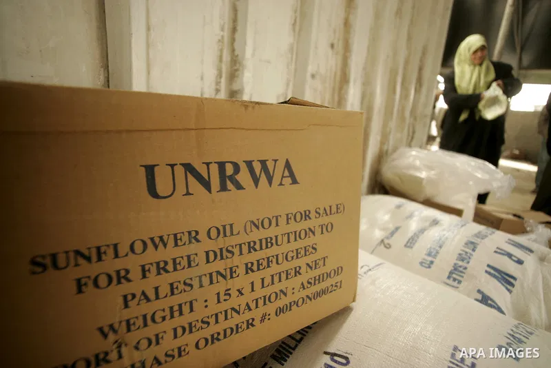 A Palestinian woman receives food aids from the United Nations Relief and Works Agency (UNRWA) at the Rafah refugee camp, in the southern Gaza Strip on February 16, 2011. Accused the owners of destroyed houses that the R...