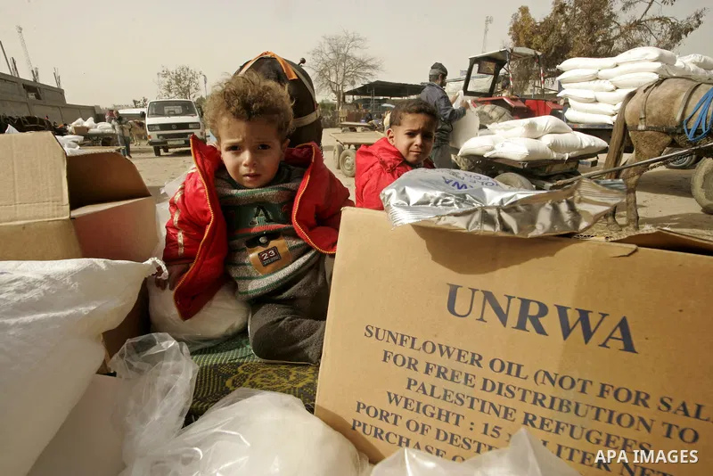 Palestinian children sit on a horse-drawn cart as Palestinians receive food aids from the United Nations Relief and Works Agency (UNRWA) at the Rafah refugee camp, in the southern Gaza Strip on February 16, 2011. Accused...