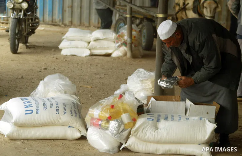 A Palestinian man receives food aids from the United Nations Relief and Works Agency (UNRWA) at the Rafah refugee camp, in the southern Gaza Strip on February 16, 2011. Accused the owners of destroyed houses that the Rel...