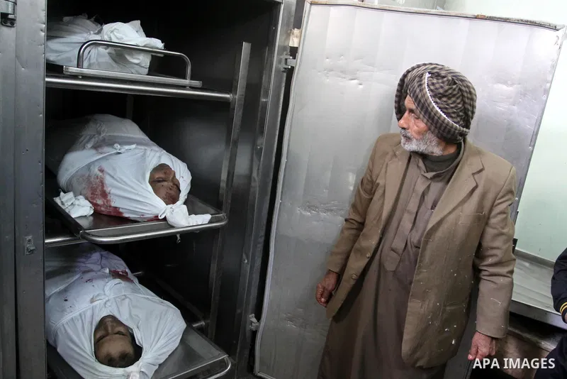 A Palestinian man looks at the bodies of the three killed Palestinians, at the morgue in Kamal Adwan hospital in the town of Beit Lahiya, northern Gaza Strip, on Feb. 17, 2011. Three Palestinian fishermen were slain on e...