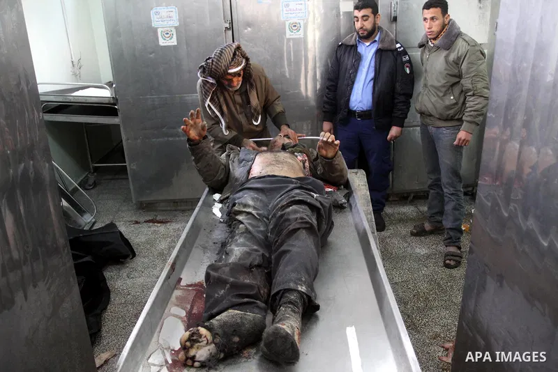 Palestinians look at the body of one of the three killed Palestinians, at the morgue in Kamal Adwan hospital in the town of Beit Lahiya, northern Gaza Strip, on Feb. 17, 2011. Three Palestinian fishermen were slain on ea...