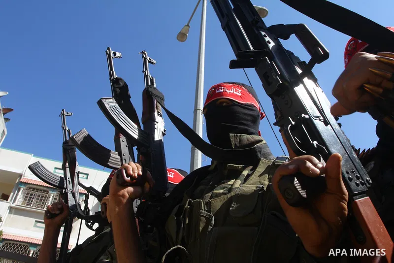 Palestinian militants hold up their weapons as they attend the funeral of three Palestinian men who were shot dead by Israeli forces, in Beit Lahia, northern Gaza Strip, on February 17, 2011. The three men were killed ov...