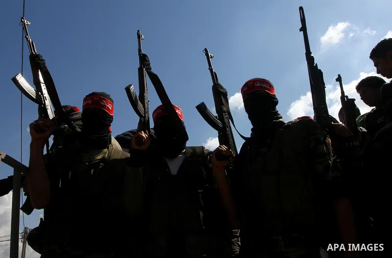 Palestinian militants hold up their weapons as they attend the funeral of three Palestinian men who were shot dead by Israeli forces, in Beit Lahia, northern Gaza Strip, on February 17, 2011. The three men were killed ov...