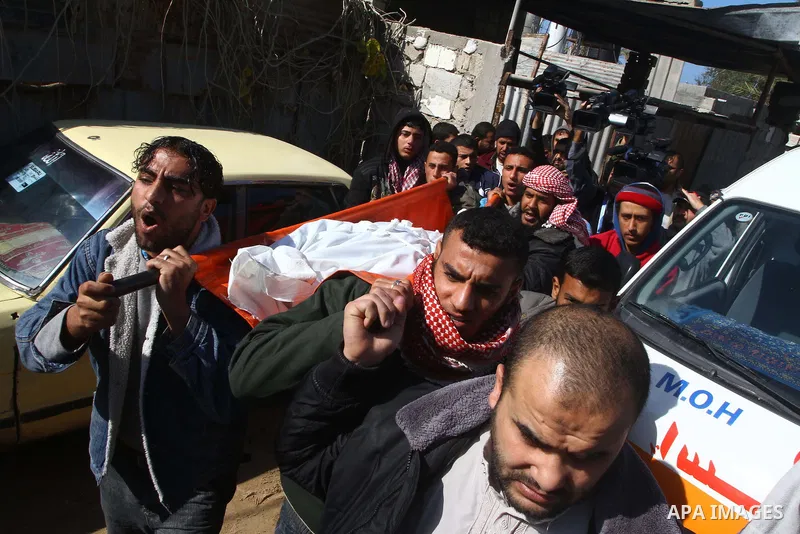 Palestinian mourners carry the body of Talat al-Rawagh, 25, one of the three Palestinians who were shot dead by Israeli forces, during his funeral in Beit Lahia, northern Gaza Strip, on February 17, 201. The three men we...