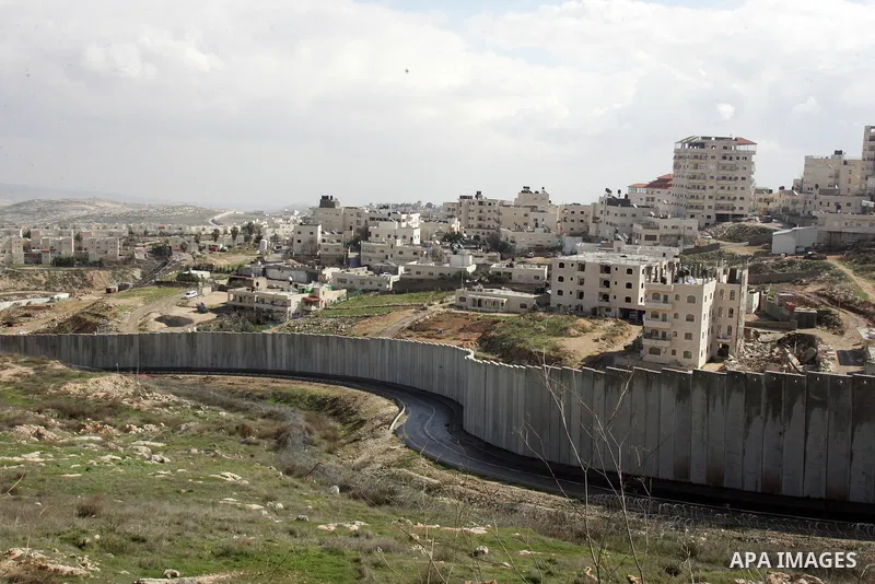 A view of the controversial Israeli separation barrier on the outskirts of Jerusalem on February 17,2011. On the top the Israeli settlement of Pisgat Zeev and on the bottom the refugee camp of Shuafat . Photo by Mahfouz...