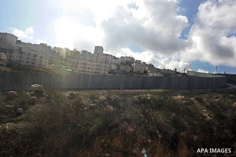 A view of the controversial Israeli separation barrier on the outskirts of Jerusalem on February 17, 2011. On the top the Israeli settlement of Pisgat Zeev and on the bottom the refugee camp of Shuafat . Photo by Mahfouz...