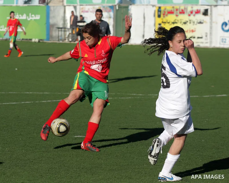 Palestinians play a football match between Deyaar team (red) and Al-Rwaa team (white) in the West Bank city of Bethlehem on Feb. 18, 2011. Within the Premier League for females at the Al-Khader Stade. Photo by Najeh Hash...