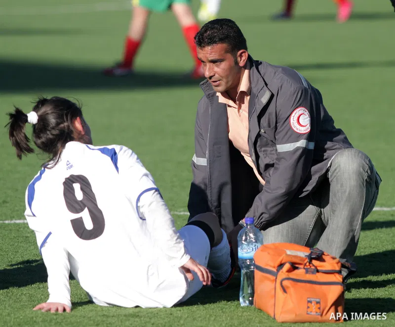 Palestinian girl receives treatment during a football match between Deyaar team (red) and Al-Rwaa team (white) in the West Bank city of Bethlehem on Feb. 18, 2011. Within the Premier League for females at the Al-Khader S...